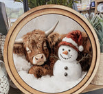 Load image into Gallery viewer, Cow Sleeping by Red White Hat Snowman Round Wood Frame Christmas Decor
