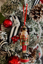 Load image into Gallery viewer, Plaid Nutcracker Ornament in Red, Dark Green, White and Gold with Black Accents
